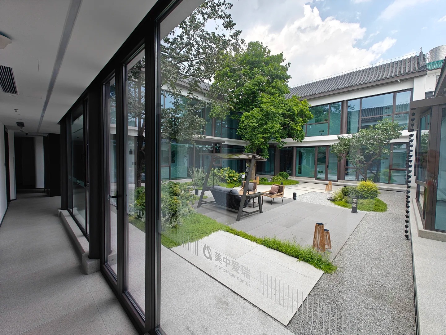 Indoor view of healing courtyard through floor-to-ceiling glass walls