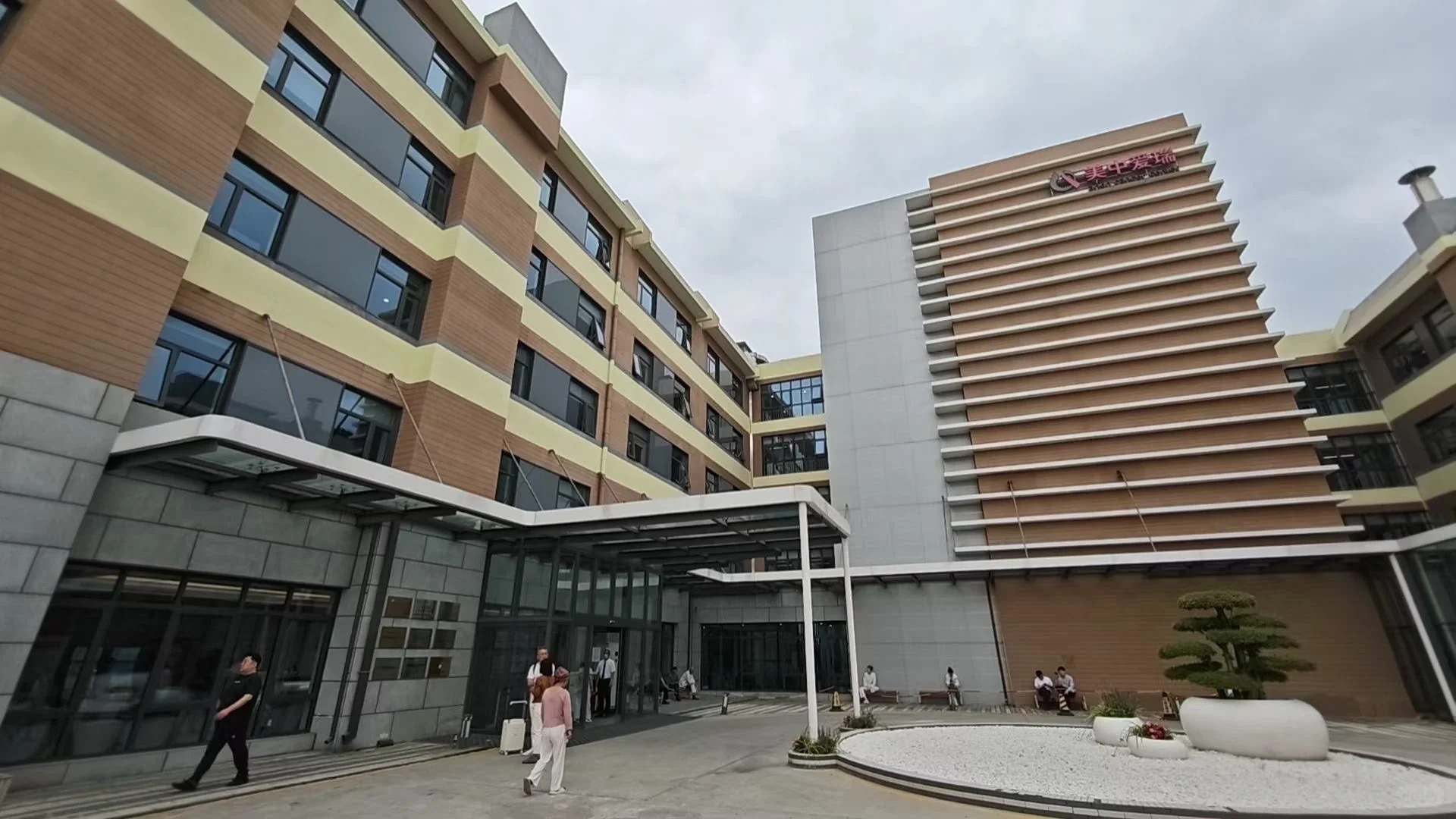 Hospital exterior courtyard entrance with modern glass canopy