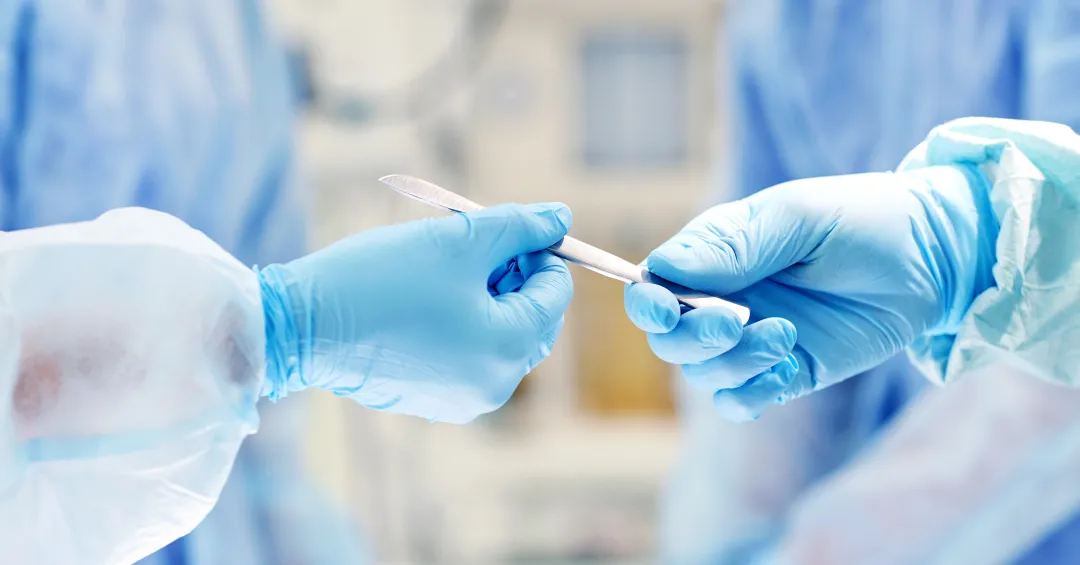 Close-up of surgical instruments being passed during a minimally invasive procedure
